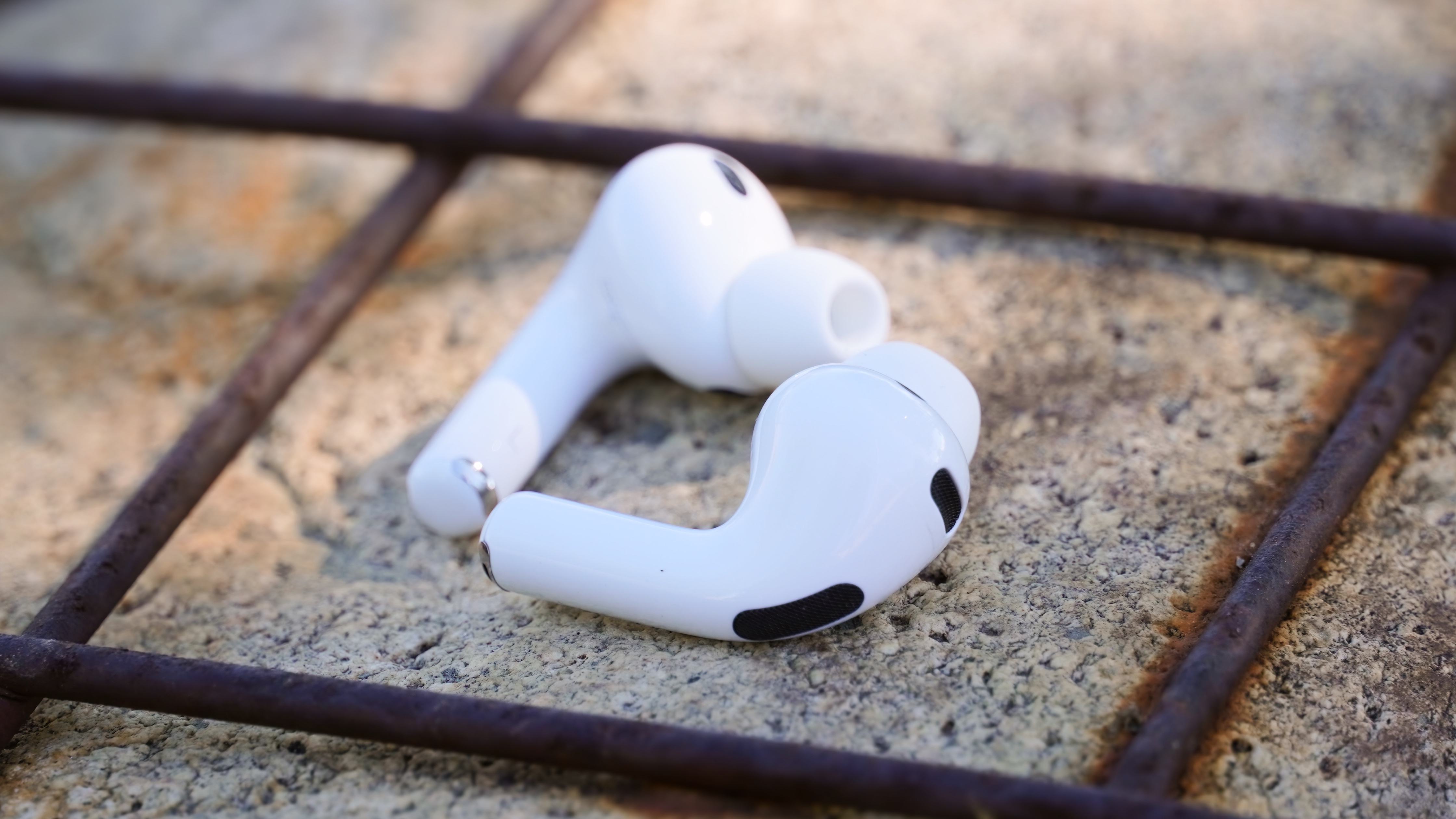 Τα AirPods Pro 3 με τη θήκη φόρτισης σε ένα πάρκο.