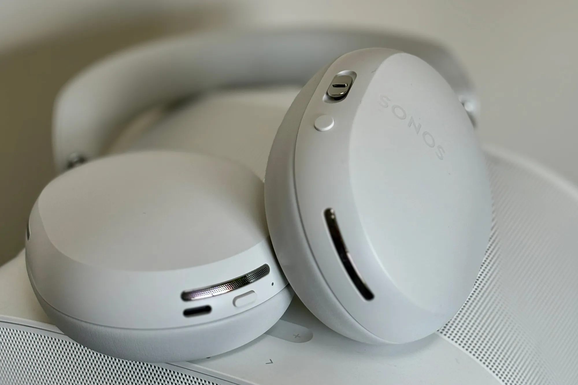 White Sonos Ace headphones sitting on top of a white Sonos Era 300 speaker