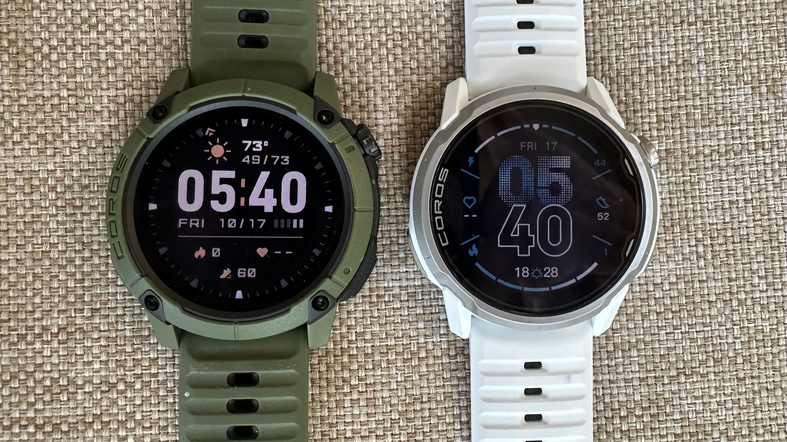 Photo of the COROS NOMAD (left) and APEX 4 (right) both sitting on a flat surface. The photo illustrates how the NOMAD's MIP display is slightly more visible than the APEX 4's.