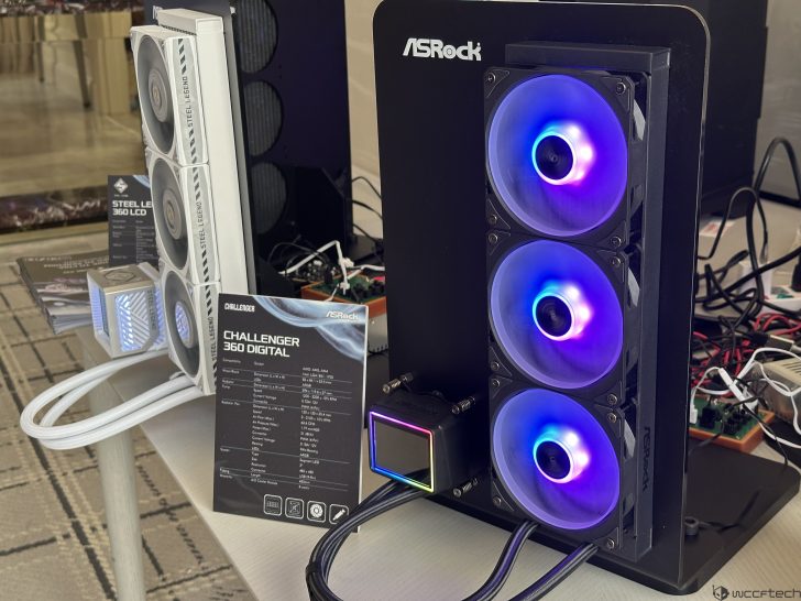 ASRock's 'CHALLENGER 360 DIGITAL' cooling system is displayed with vividly illuminated fans, alongside an ASRock Steel Legend 360 LCD cooling unit and product specifications on a table.