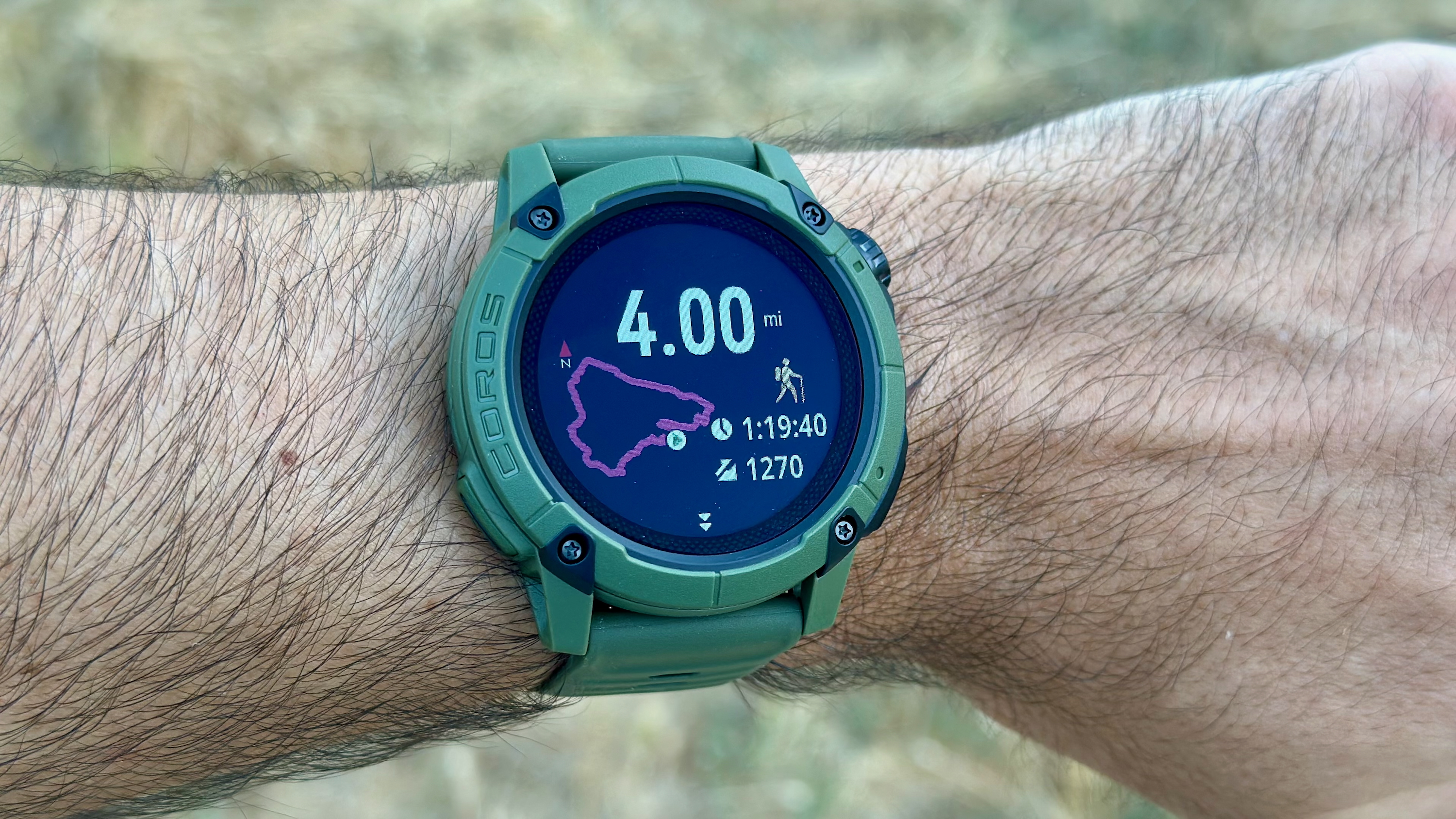 The COROS NOMAD watch on a wrist showing a post-hike summary of the time, distance, and elevation gain.