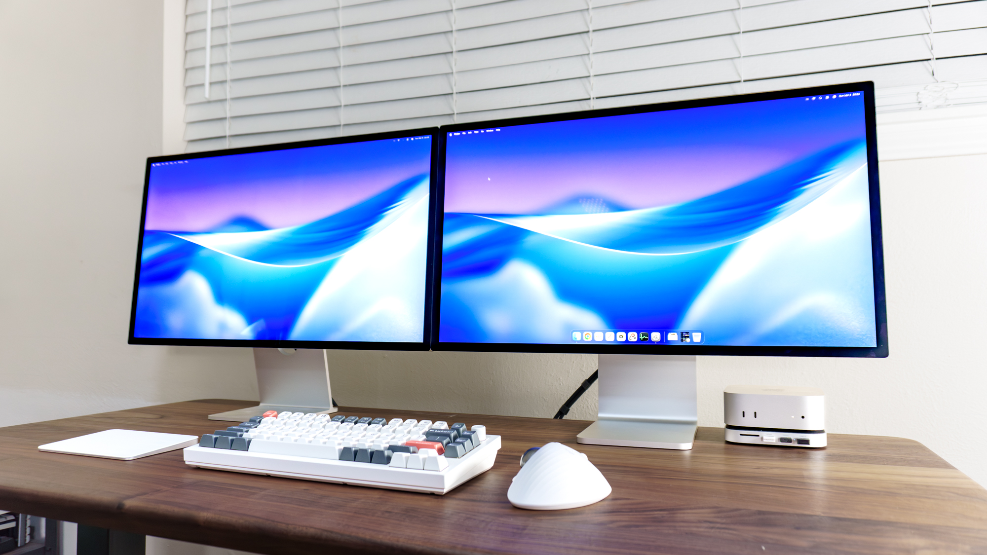 The new Apple Studio Display XDR on the right with an original Studio Display connected to it via the downstream Thunderbolt 5 port around back