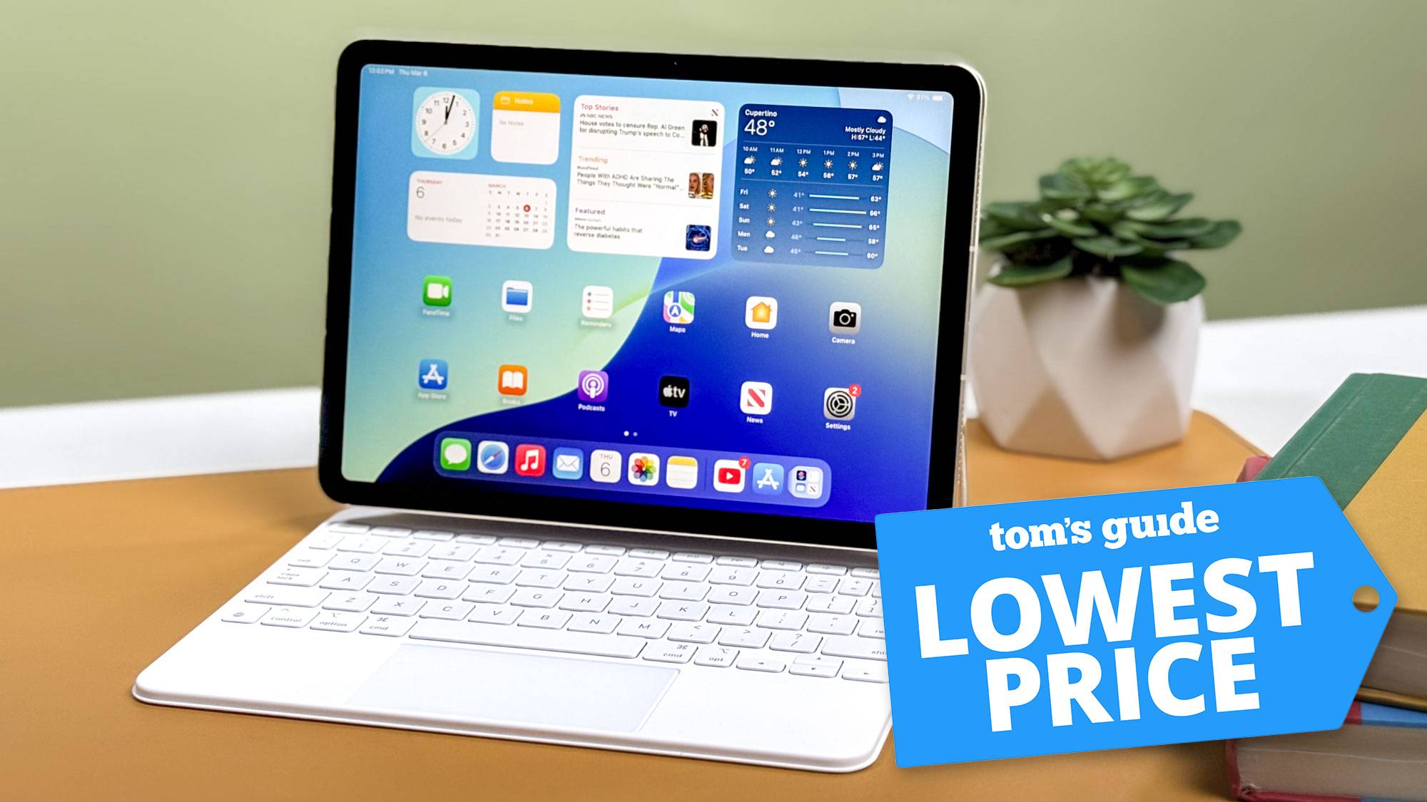 Το iPad Air M3 στο Magic Keyboard κάθεται στο γραφείο με γλάστρα στο φόντο με το σήμα Tom's Guide Loest Price