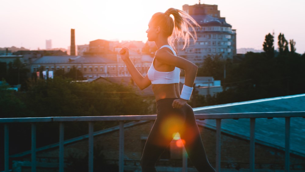 μια φωτογραφία μιας γυναίκας που τρέχει την ανατολή του ηλίου