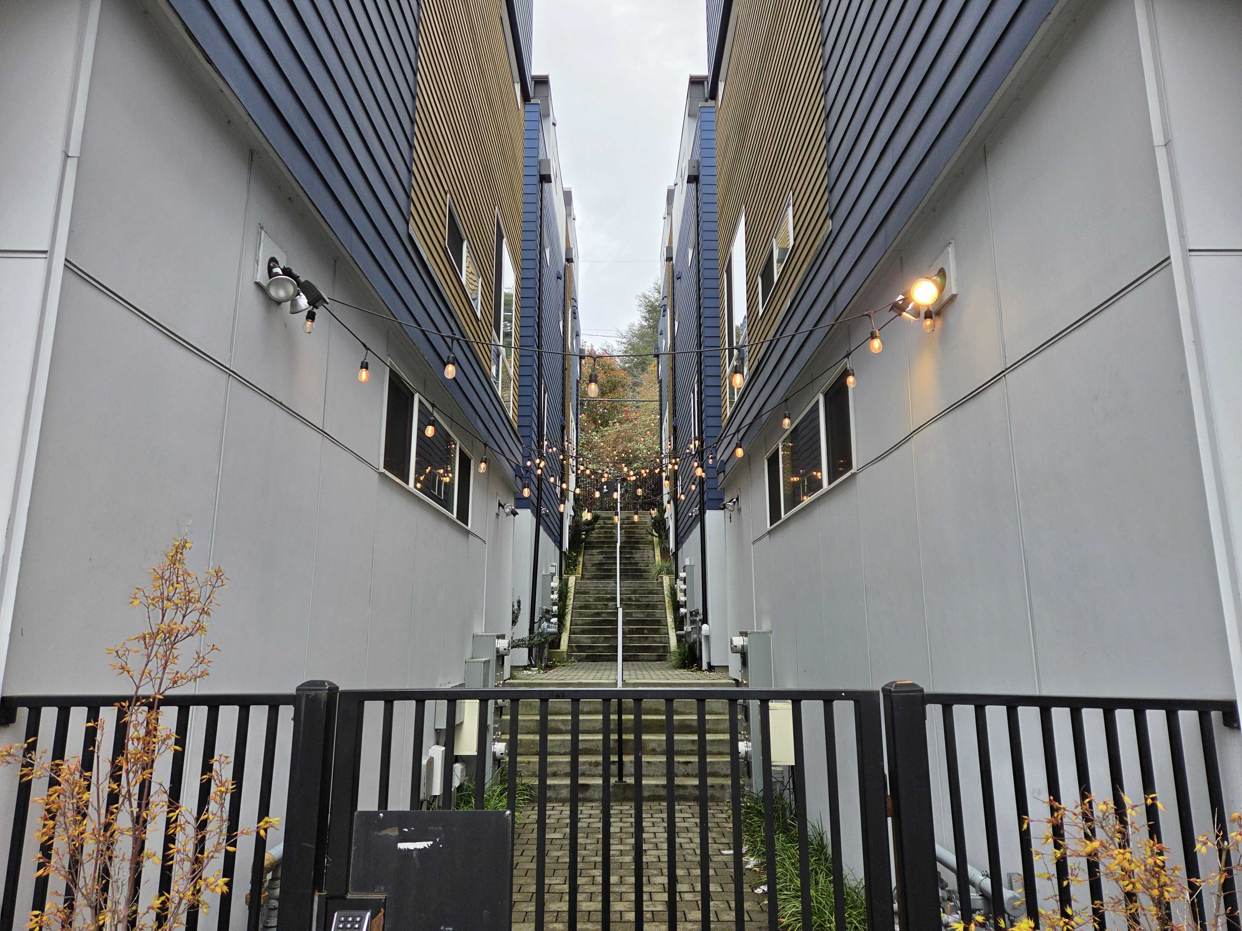 A staircase between two buildings and lights strung between them