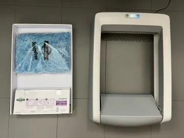 Αυτοκαθαριζόμενο κουτί απορριμμάτων PetSafe στο δάπεδο δίπλα από χαρτόνι αναπλήρωσης