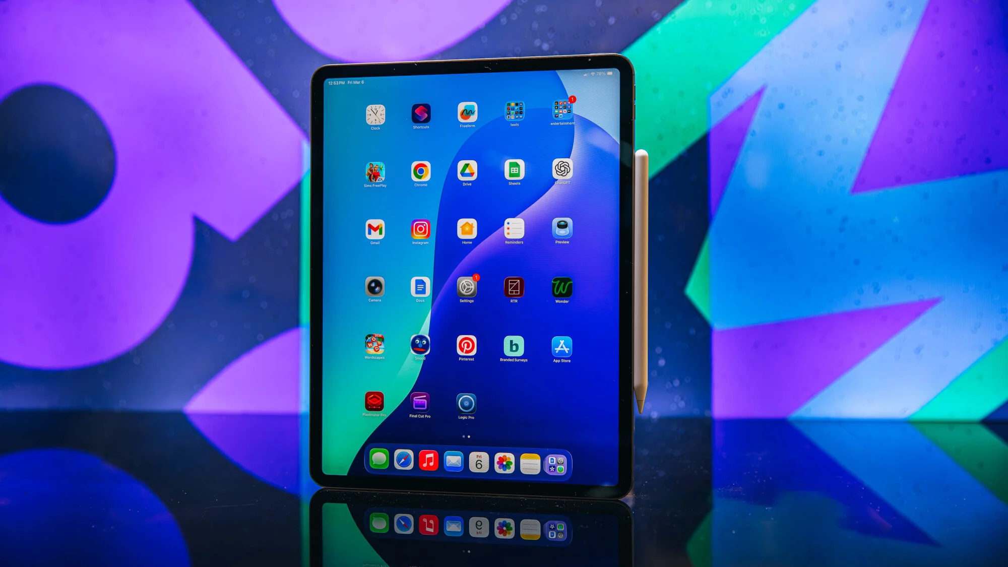 iPad Air 13 ιντσών με Apple Pencil, κάθεται σε ένα τραπέζι με πολύχρωμο φόντο.