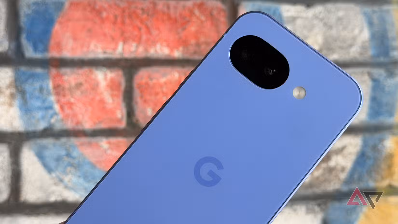 Το Google Pixel 10a σε λεβάντα κρατιέται σε έναν τοίχο
