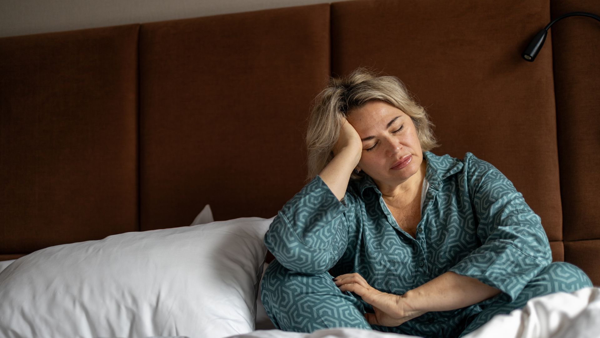 Μια γυναίκα με μπλε πιτζάμες ξυπνά στις 3 τα ξημερώματα από αϋπνία.