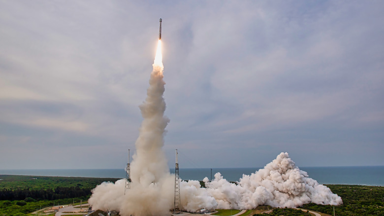 ευρεία θέα του πυραύλου που απογειώνεται από το σημείο εκτόξευσης με τον καπνό να βγαίνει έξω