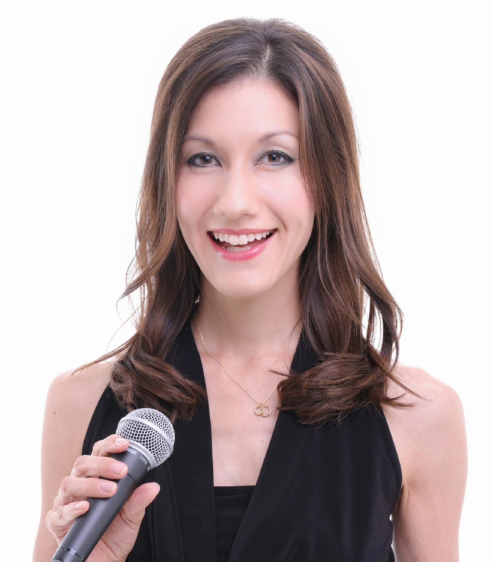 Η Emi Evans holding a microphone, χαμογελάει.